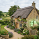 Traditional Cotswold stone cottage with energy performance rating overlay - EPC reform delay 2027